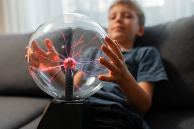 Free photo kids interacting with a plasma ball