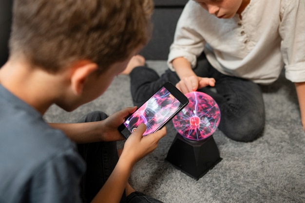 Free photo kids interacting with a plasma ball