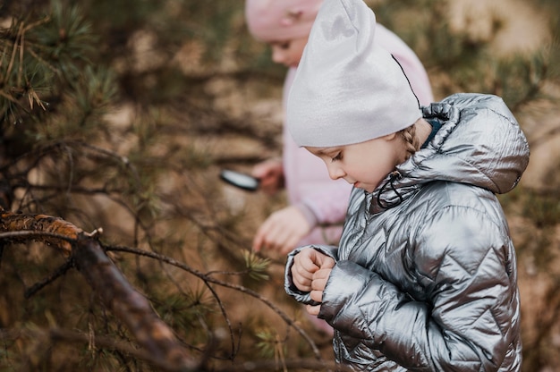 Kids learning science in the nature with a magnifier