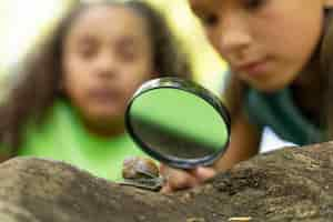 Free photo kids looking together at a snail