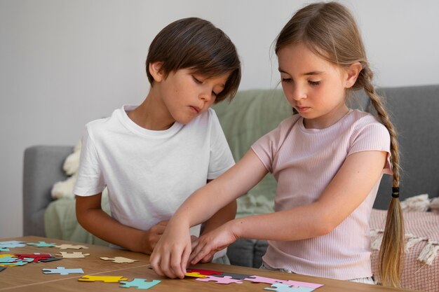 Free Photo kids making puzzle together side view