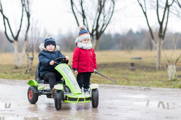 Kids playing outside with green cart