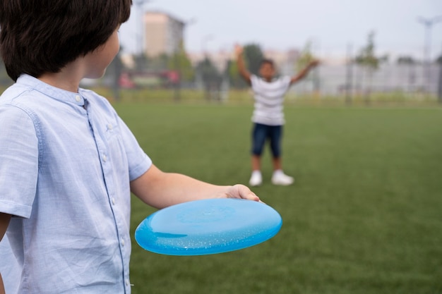 Free photo kids playing with frisbee close up