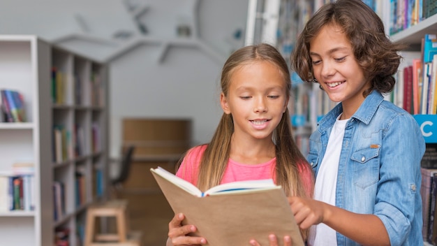 Kids reading from a book with copy space