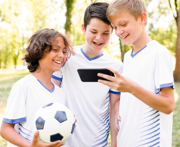 Kids in sportswear looking at a phone