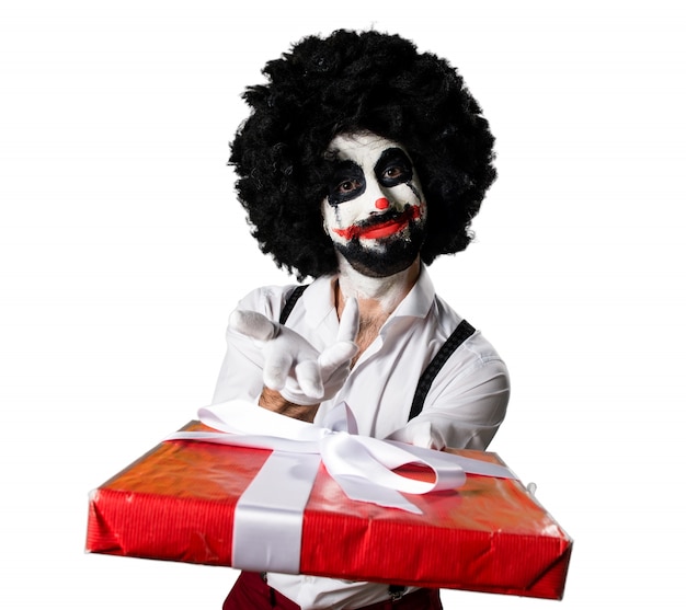 Free photo killer clown holding a gift