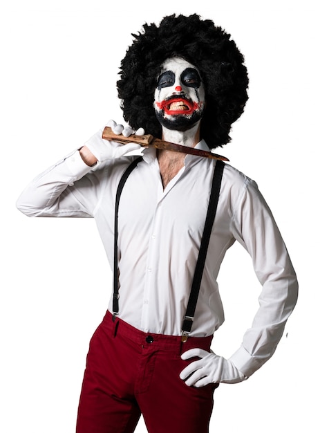 Free Photo killer clown with knife making suicide gesture