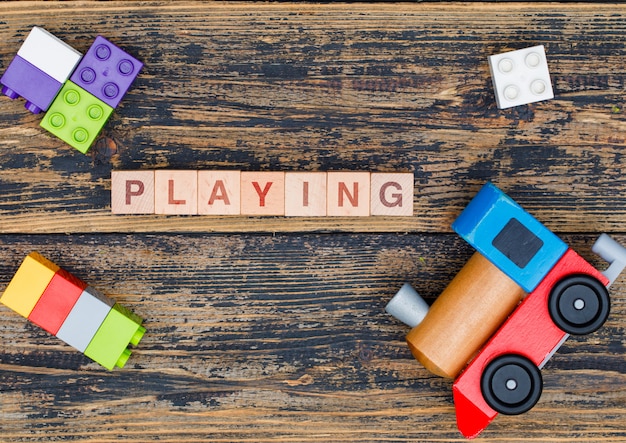 Free Photo kindergarten concept with wooden cubes, kid toys on wooden background flat lay.