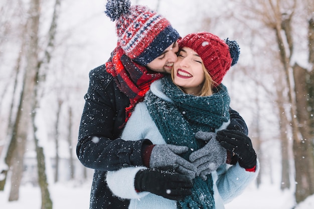 Kissing laughing couple in snowfall