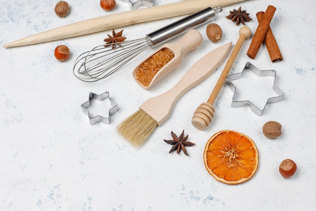 Free photo kitchen baking utensils with spices for cookies and cookie cutters on light surface