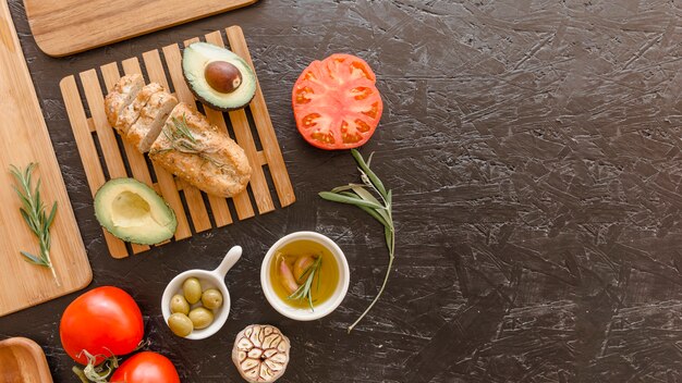 Kitchen table with vegetables bread and oil 