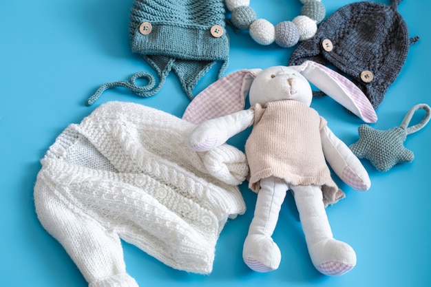 Knitted baby clothes and accessories on blue