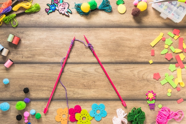 Free photo knitted needles with purple yarn inside the decorative elements on table