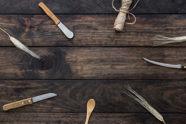 Knives and wheat near spoon and rope