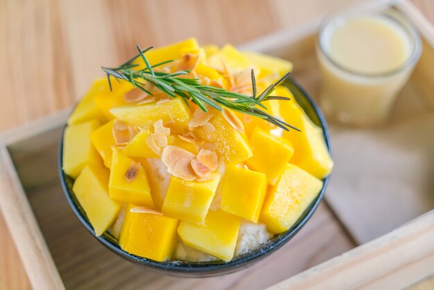 Korean style fresh mango shaved ice on wood table .