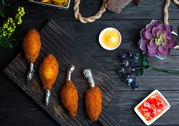 Kyiv cotletes with sauces on wooden board