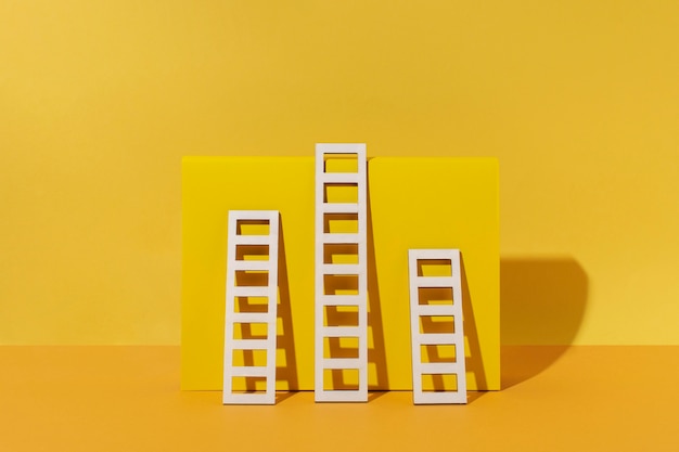 Free photo ladders arrangement with yellow background