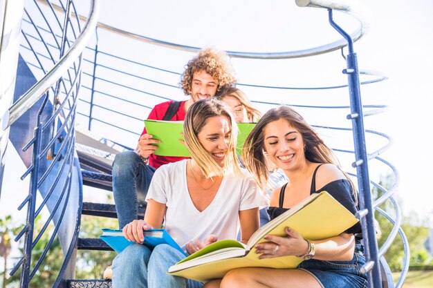 Ladies studying on staircase near friends