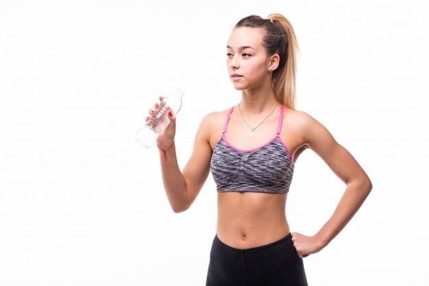 Lady drinking water from a transperent bottle on a white