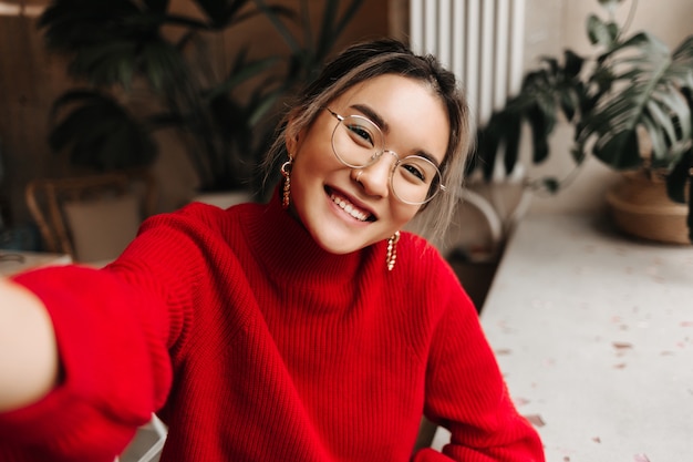 Lady in glasses and massive earrings makes selfie