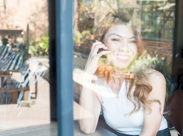 Free Photo lady happily using mobile phone in coffee shop