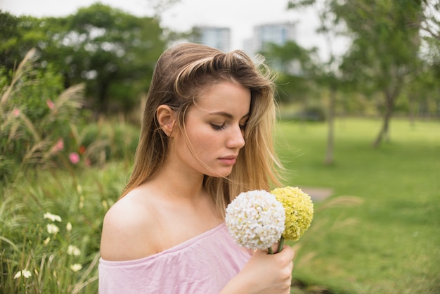 Free photo lady holding bright flowers in city park