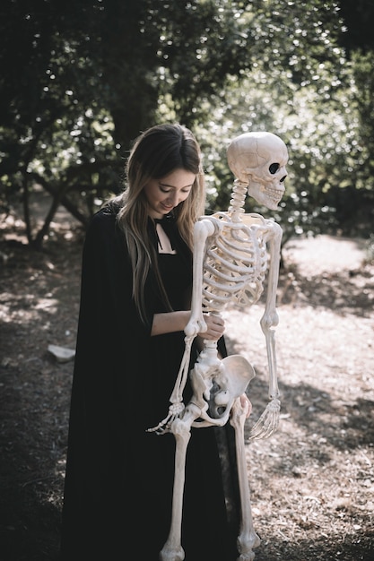 Free photo lady keeping skeleton and looking down