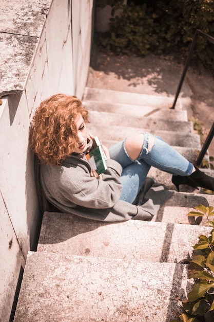 Free photo lady leaning on wall and holding books