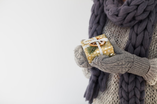 Free Photo lady in mittens with gift box in hands