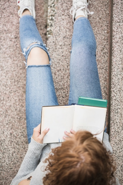 Free photo lady reading book on steps