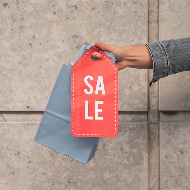 Lady's hand with shopping packet and sale tablet