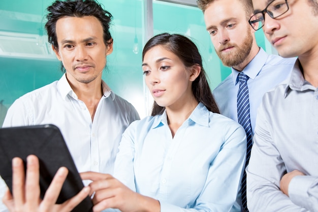 Free photo lady showing information on tablet to colleagues