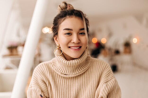 Lady in stylish beige oversize sweater looks into front