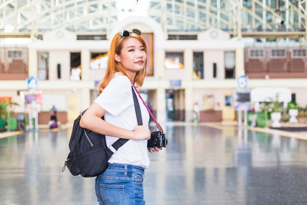 Lady with backpack and camera on railway station