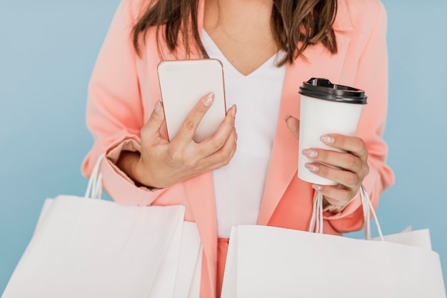 Lady with coffee and smartphone on blue background