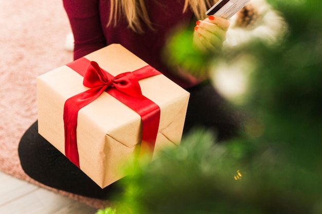 Free photo lady with gift box and plastic card on carpet