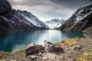 Free photo laguna del inca lake surrounded by high mountains covered in snow in chile