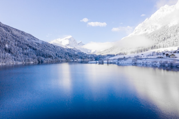 Free photo lake by the snow-covered hills captured on a sunny day