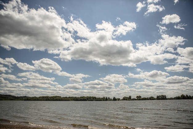 Free Photo a lake under the cloudy sky with a forest