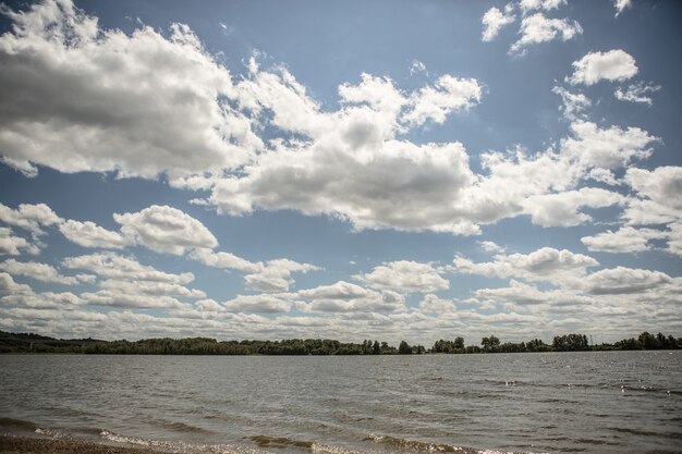 A lake under the cloudy sky with a forest