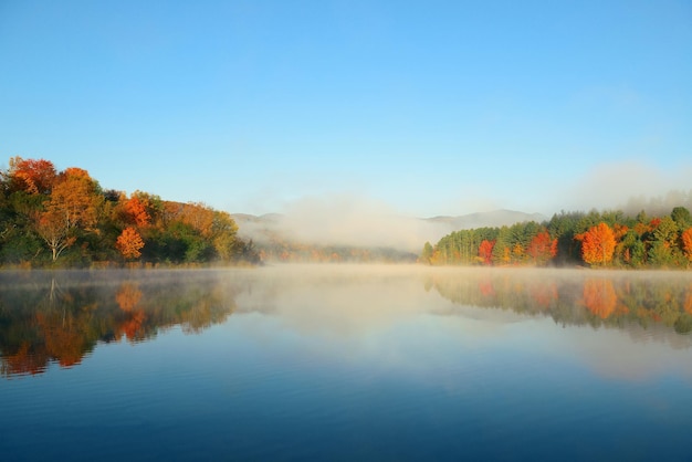 Lake fog with Autumn foliage and mountains with reflection in New England Stowe