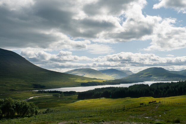 Lake Loch Tulla surrounded by mountains and meadows in the UK