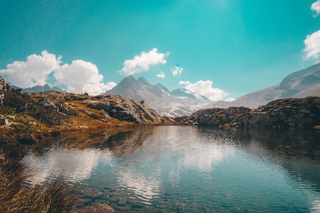 Lake near mountain under blue sky during daytime