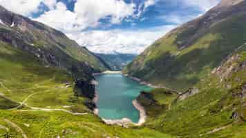 Free photo lake surrounded by hills and greenery in the kaprun high mountain reservoirs, austria