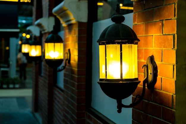 Free Photo lamp against a red brick wall at night.