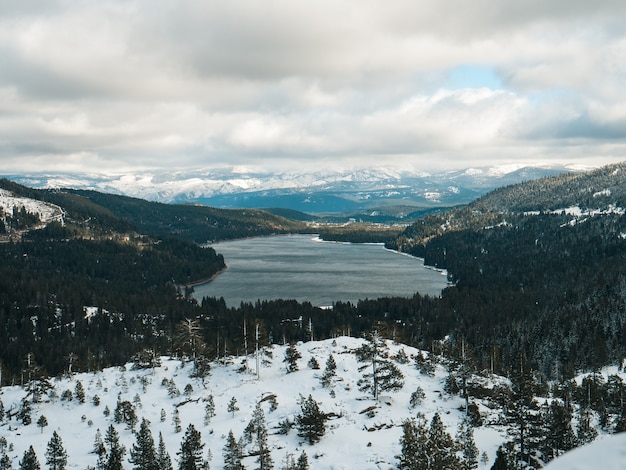 Free photo land covered with snow overlooking the donner lake in truckee, california under cloudy skies