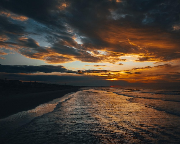 Landscape of a beach surrounded by the sea under the sunlight during a beautiful sunrise