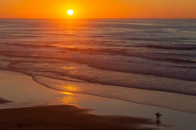 Landscape of a beautiful sunset reflecting on sea from the beach in Portugal, Algarve