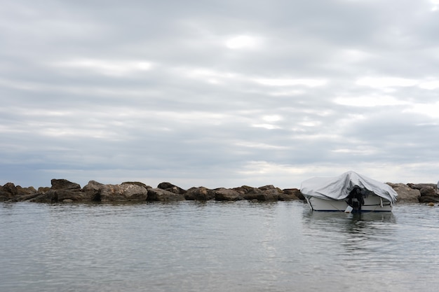 Free Photo landscape of covered boat on the sea under a cloudy sky