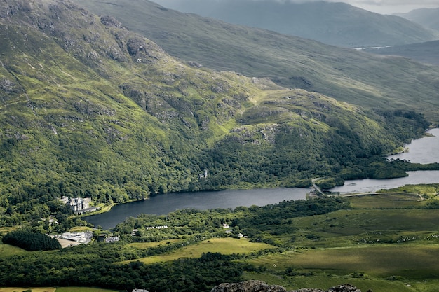 Landscape of the hills covered in greenery under a cloudy sky in Connemara National Park, Ireland